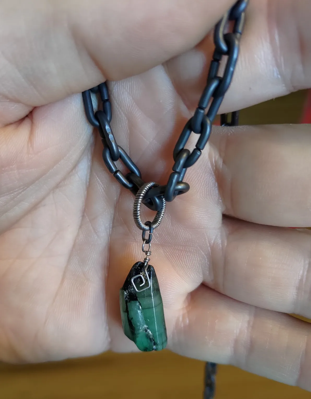 Tumbled raw emerald pendant with Ti